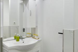 a white bathroom with a sink and a mirror at Auszeit in der Heide mit Terrasse in Bienenbüttel +17 photos