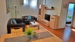a living room with a couch and a television at Gardenia Apartman in Esztergom