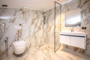 a bathroom with a toilet and a sink and a mirror at Comfort Boutique Hotel in Tirana +103 photos