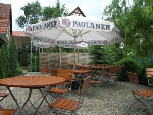 an outdoor patio with tables and chairs and umbrellas at Hotel Gasthof Ratstube in Kirchheim unter Teck