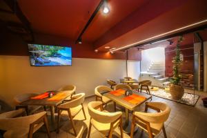 a restaurant with tables and chairs and a tv on the wall at Comfort Boutique Hotel in Tirana