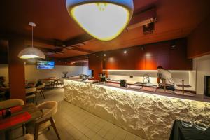 a man standing at a kitchen counter in a restaurant at Comfort Boutique Hotel in Tirana