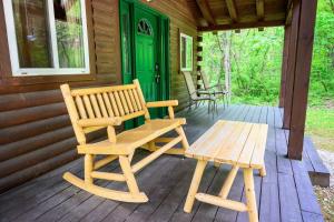 a wooden bench on the porch of a cabin at Wren's Nest in Logan