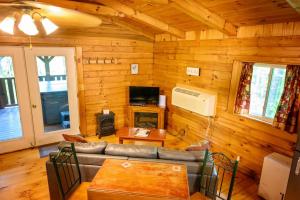 a living room with a couch and a fireplace in a log cabin at Wren's Nest in Logan