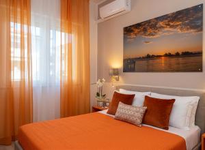 a bedroom with an orange bed with a painting on the wall at La locanda di Gioele in Lido di Camaiore