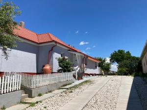 a house with a white fence next to a road at Vadvirágos in Igal