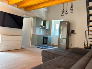 a living room with a couch and a kitchen at Amarè House in Catania