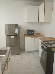 a small kitchen with a stove and a sink at Apart Hotel Astore in Antofagasta