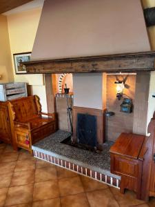a living room with a fireplace in front of it at Il Brolo in Avenone