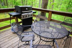 a grill and a table and chairs on a deck at Bear Hollow in Logan