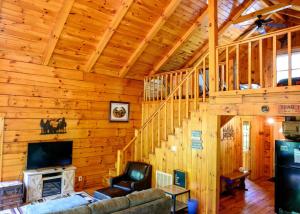 a living room with a staircase in a log cabin at Bear Hollow in Logan