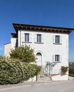 a white house with a gate and flowers at La casa di Montegiardino in San Marino