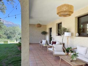 a patio with white chairs and a table and windows at Hotel Rural Xerete in Navaconcejo