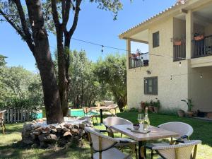a patio with a table and chairs in front of a house at Hotel Rural Xerete in Navaconcejo