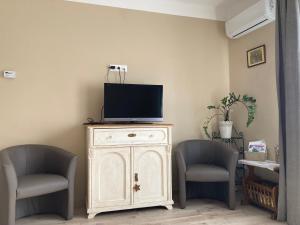 a tv on top of a cabinet with two chairs at Vadvirágos in Igal