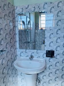 a bathroom with a white sink and a mirror at Highway sunset in Namulanda
