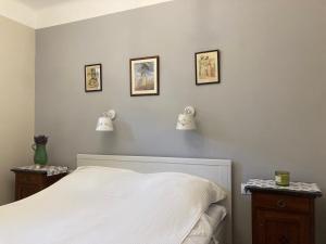 a bedroom with a white bed and three pictures on the wall at Vadvirágos in Igal