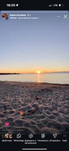 a screenshot of a beach with a picture of the sunset at Guest House Nurdana in Tossor