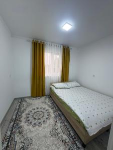 a small bedroom with a bed and a rug at Guest House Nurdana in Tossor +10 photos