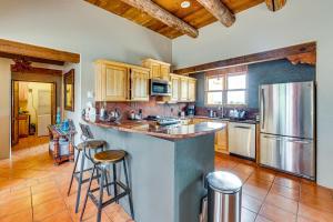 a kitchen with a counter and some stools in it at Adobe-Style Taos Home with Great Views! in Taos