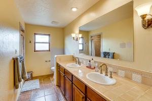 a bathroom with two sinks and a large mirror at Adobe-Style Taos Home with Great Views! in Taos +18 photos