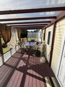 a wooden deck with a table and a picnic table at Английский домик in Lapmežciems +10 photos