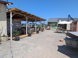 a patio with a pavilion with tables and umbrellas at Mara si Marea in Năvodari +8 photos