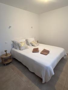 a large white bed with two towels on it at Appartement Bastia Cardo Village in Bastia