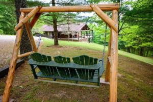 a swing in a park with a house in the background at Moonlight Ridge in Laurelville