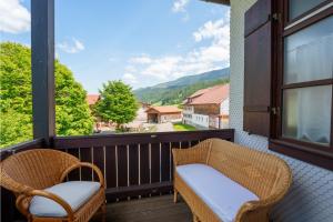 a balcony with two chairs and a view of a mountain at Direkt am Wanderweg, Ferienwohnung im Allgäu nahe Oberstaufen in Oberstaufen