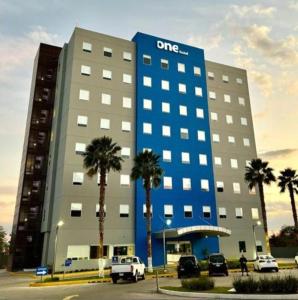 a dmg building with palm trees in front of it at One Irapuato in Irapuato