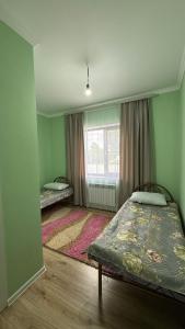 a bedroom with two beds and a window at Kolsai Terrassa in Saty