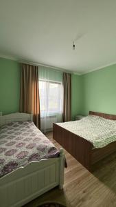 a bedroom with two beds and a window at Kolsai Terrassa in Saty +40 photos