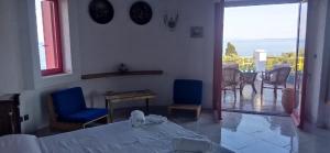 a bedroom with a bed and chairs and a balcony at La casa di Aurora - Room A - Boutique Hotel in Agios Ioannis Peristerion