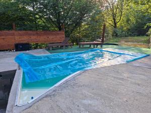 a swimming pool with a bench and a picnic table at Cabana Alpha in Baia Mare