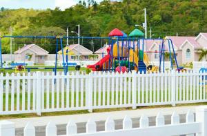 a white fence in front of a playground at Caymanas Estate House in Portmore