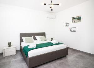 a bedroom with a bed with two towels on it at Apartment Ballin in Primošten