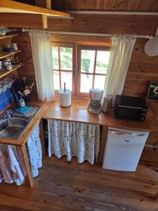 a kitchen in a log cabin with a counter and a sink at Niebieski domek na Kaszubach in Dziemiany