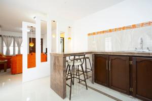 a kitchen with a counter and a bar with stools at La Casita Perfect Location in Cozumel