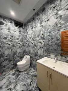 a black and white bathroom with a sink and a mirror at Elite Enclave inn in Islamabad