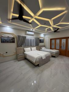 a large bedroom with two beds and a ceiling at Elite Enclave inn in Islamabad