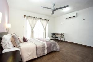 a bedroom with a bed and a ceiling fan at La Casita Perfect Location in Cozumel
