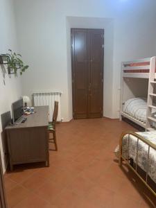 a room with a desk with a computer and bunk beds at Il Quadrifoglio Nascosto in Pontassieve