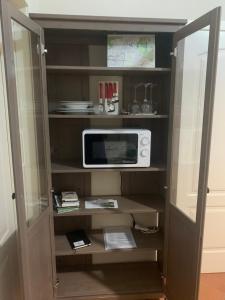 a cabinet with a microwave on top of it at Il Quadrifoglio Nascosto in Pontassieve +23 photos