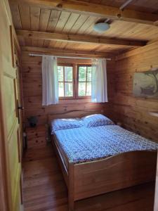 a bedroom with a bed in a log cabin at Niebieski domek na Kaszubach in Dziemiany