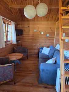 a living room with a blue couch and a table at Niebieski domek na Kaszubach in Dziemiany