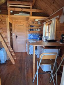 a kitchen with a table and chairs in a cabin at Niebieski domek na Kaszubach in Dziemiany