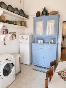 eine Küche mit einer Waschmaschine und einem blauen Schrank in der Unterkunft Loggi House in Kástron