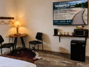 a room with a bed and a table and a tv at Elk Antler Inn in Thermopolis