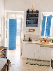 eine Küche mit blauen Türen und weißen Schränken in der Unterkunft Loggi House in Kástron